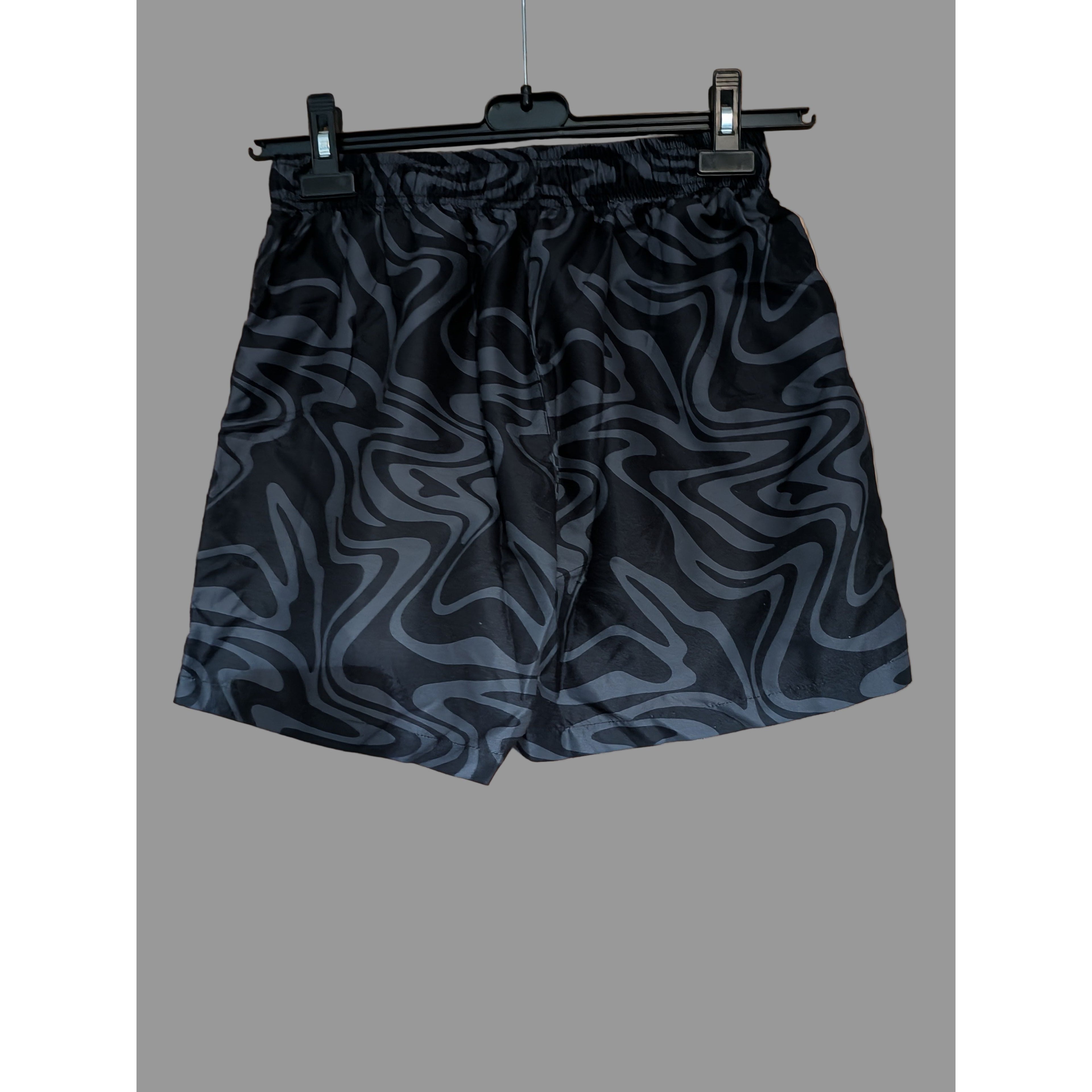 Black patterned shorts on a hanger