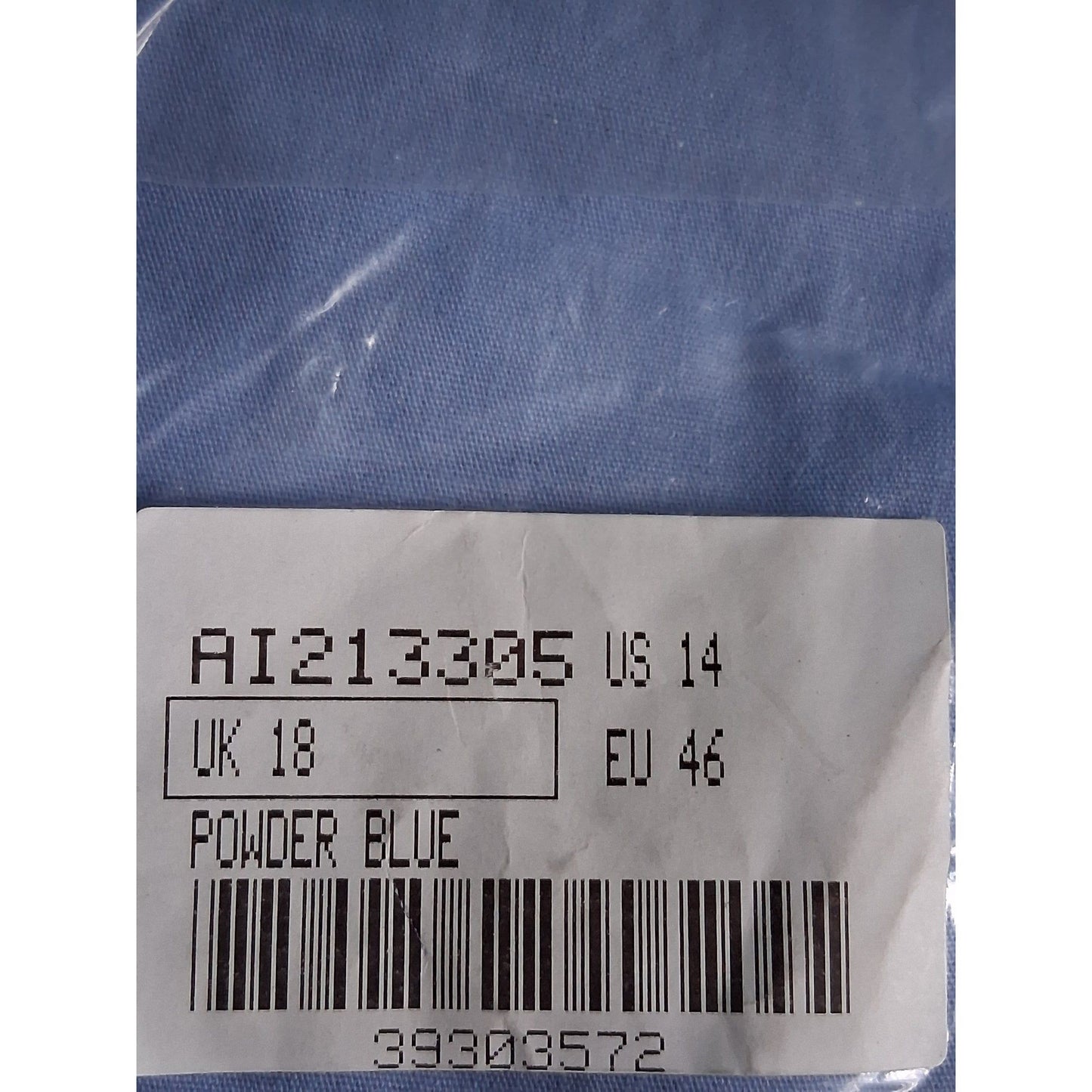 Clothing label with size and code information on a blue fabric background