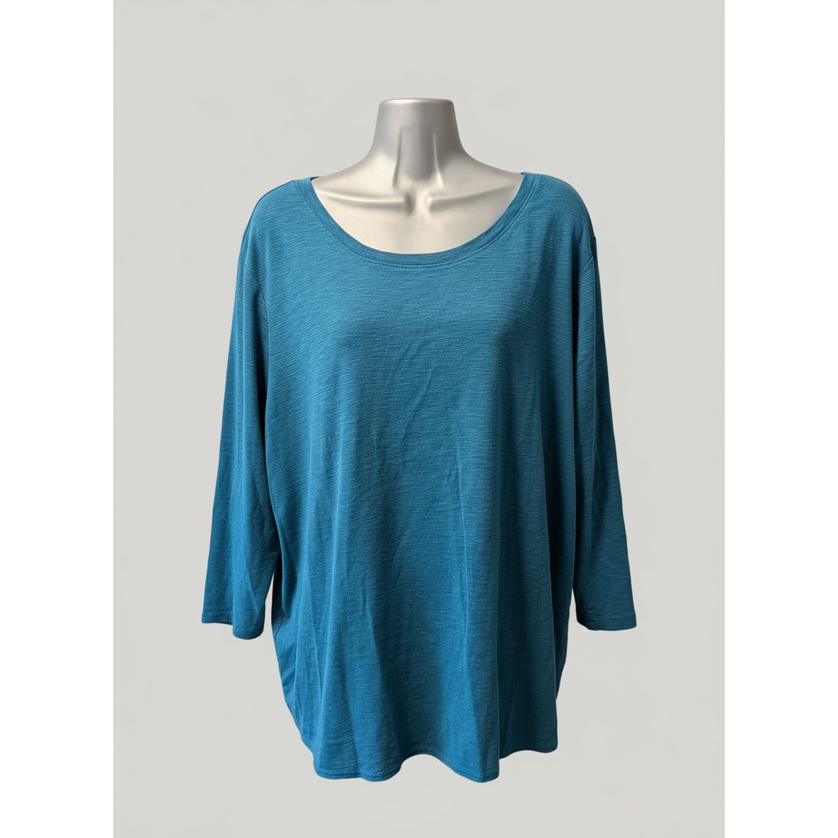 Blue long-sleeve shirt on a mannequin in front of a tiled wall.