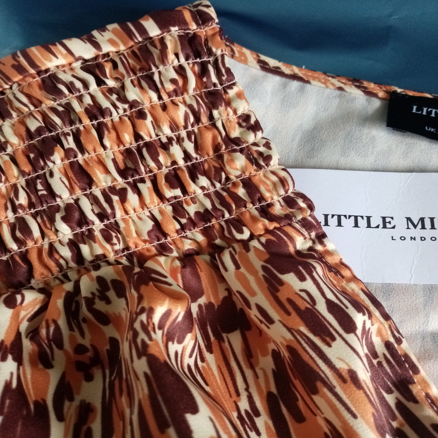 Patterned fabric with a visible brand label on a blue background