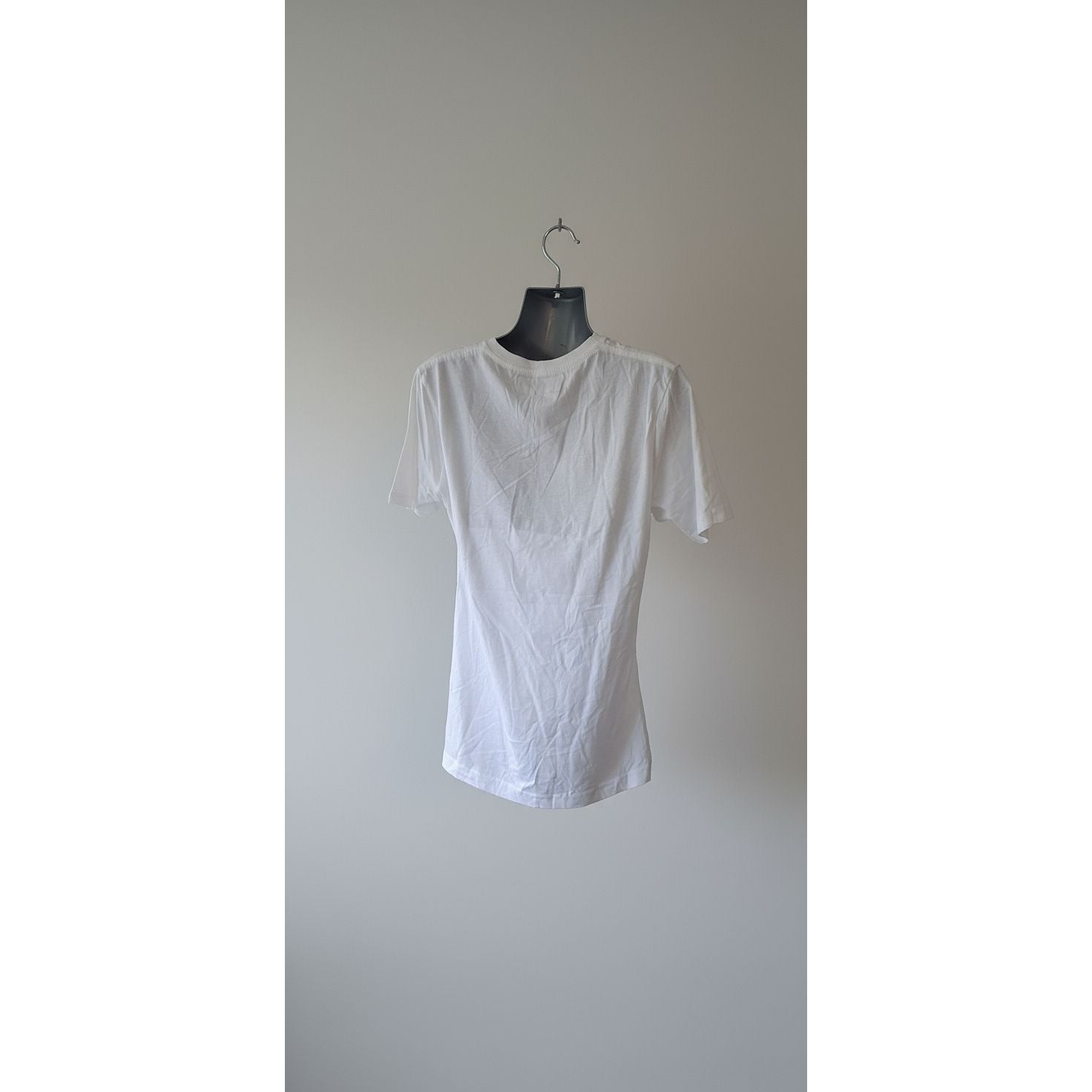 White shirt on a hanger against a neutral background