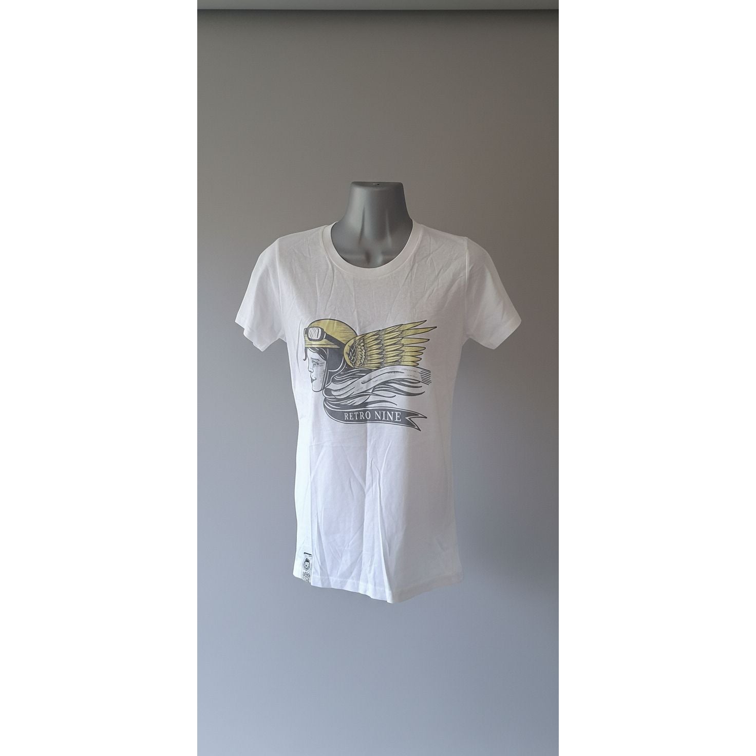 White t-shirt with a graphic design on a mannequin against a tiled wall.