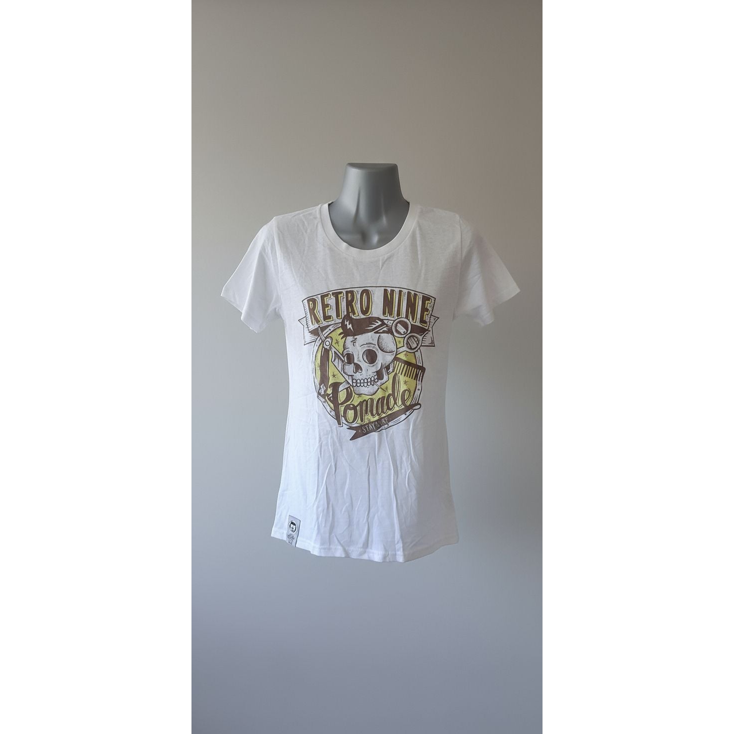 White t-shirt with graphic design on a mannequin against a tiled wall.