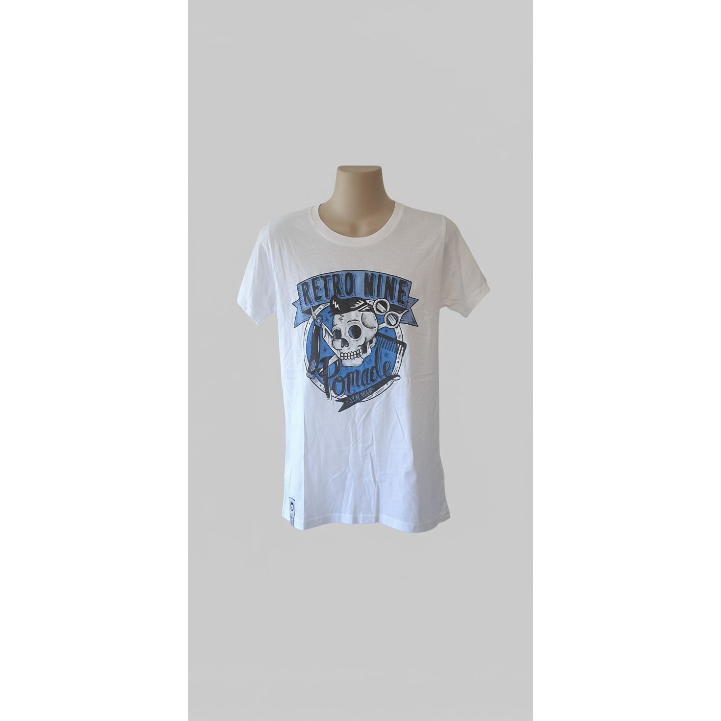 White t-shirt with blue graphic design on a mannequin against a tiled wall.