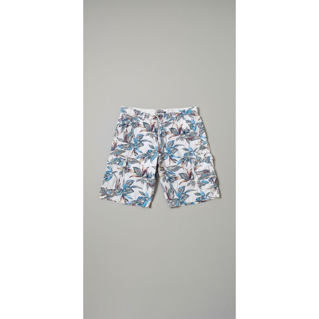 Floral-patterned pants on a hexagonal tiled floor with a dog and person's feet visible.