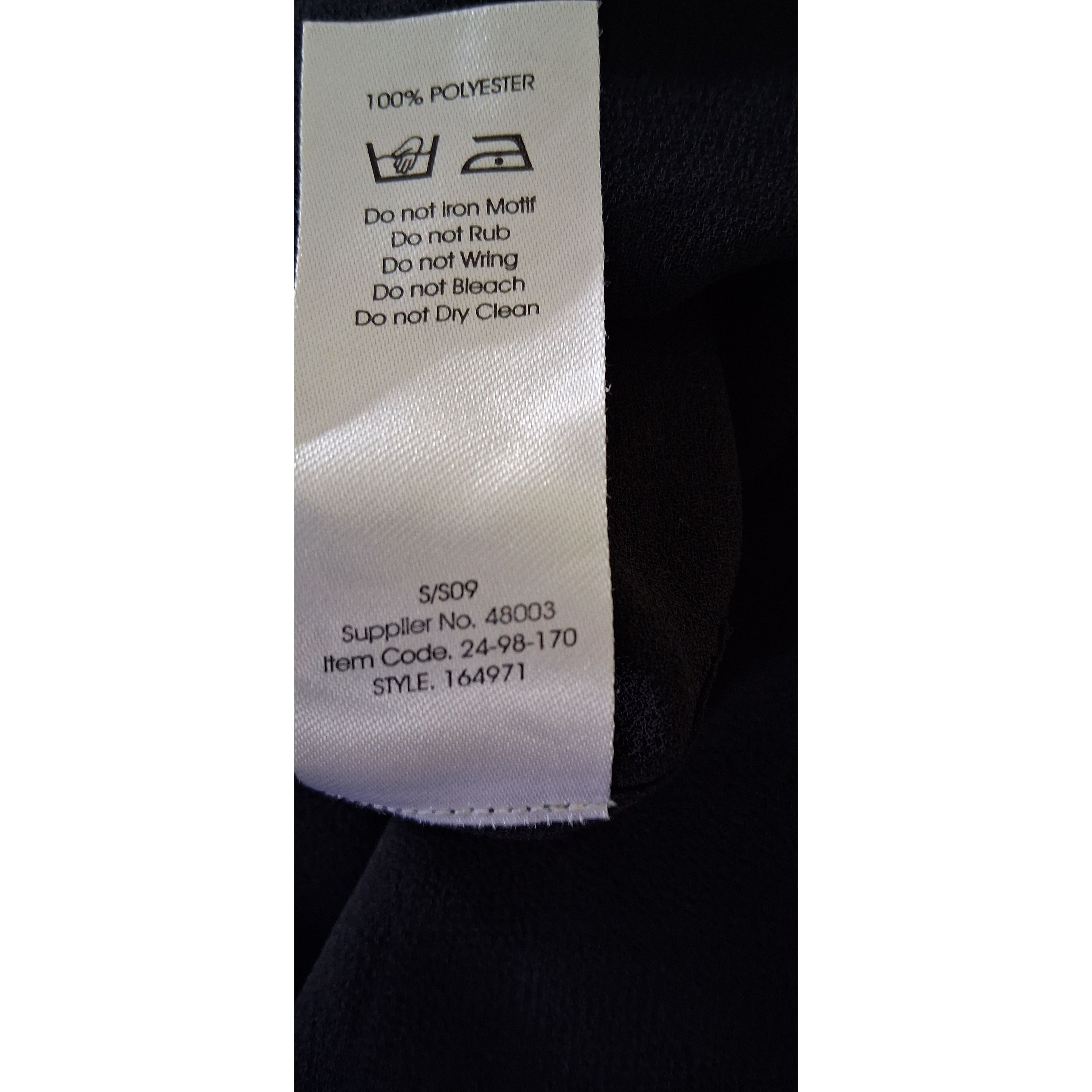 Close-up of a clothing label with text on a black background