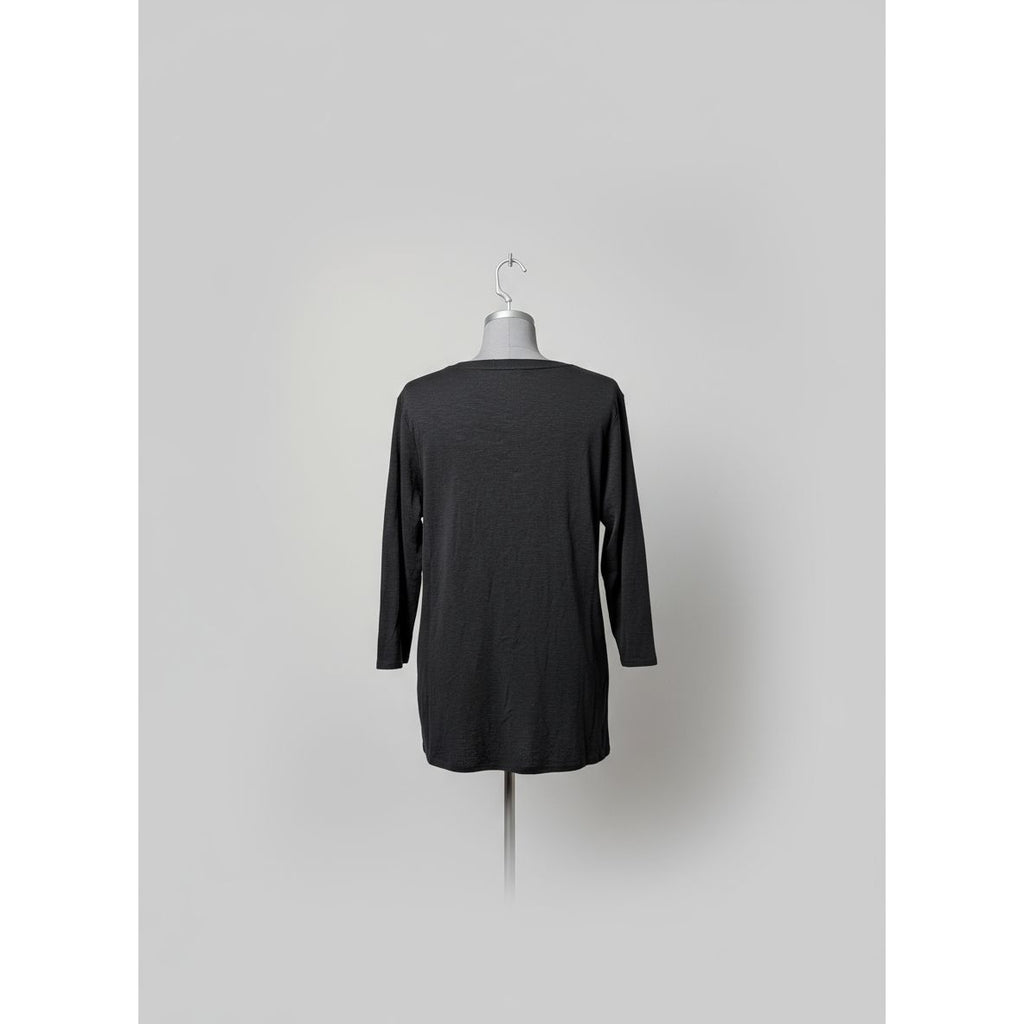 Dark gray long-sleeve shirt on a mannequin against a tiled wall.