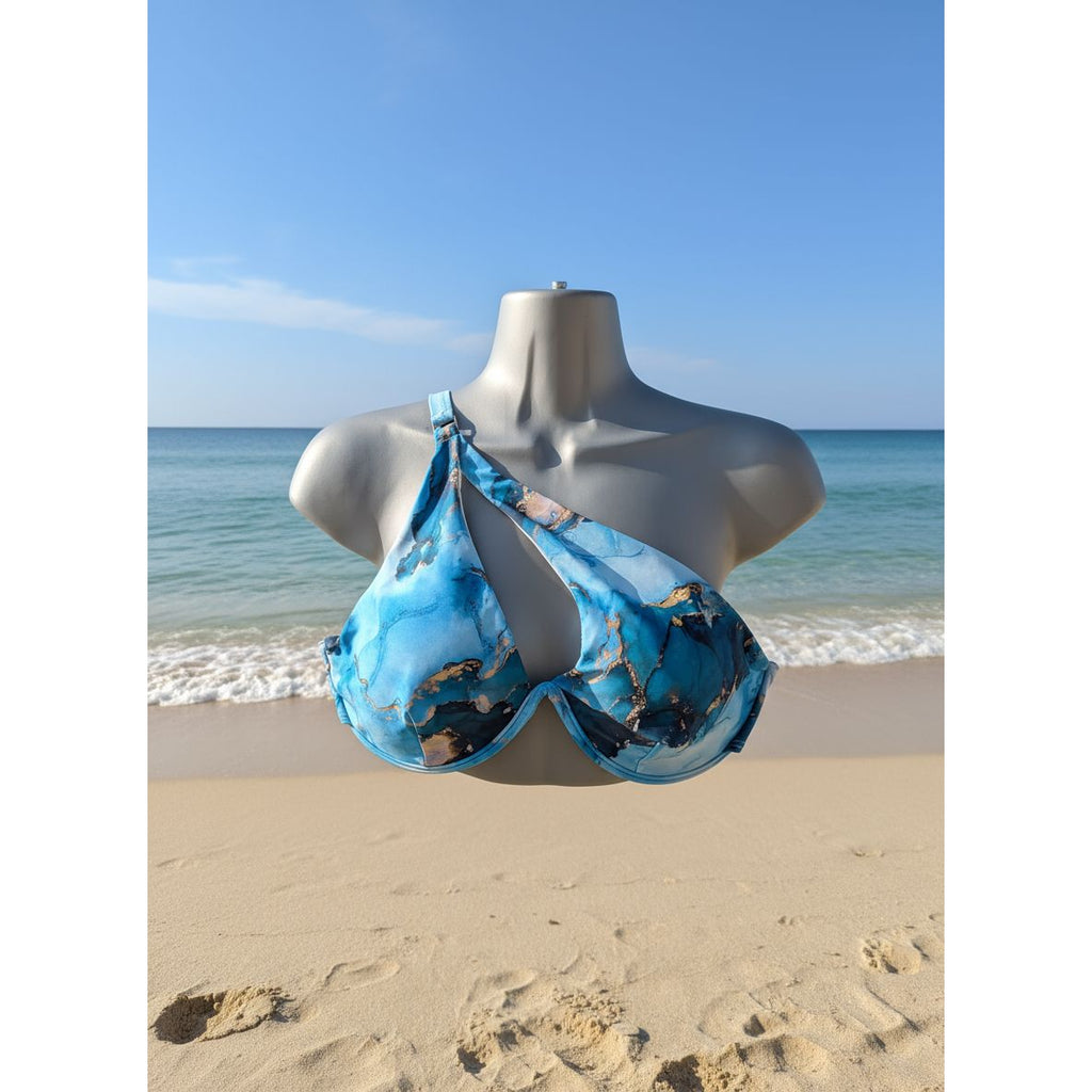 Mannequin wearing a blue bikini with gold accents in a store setting