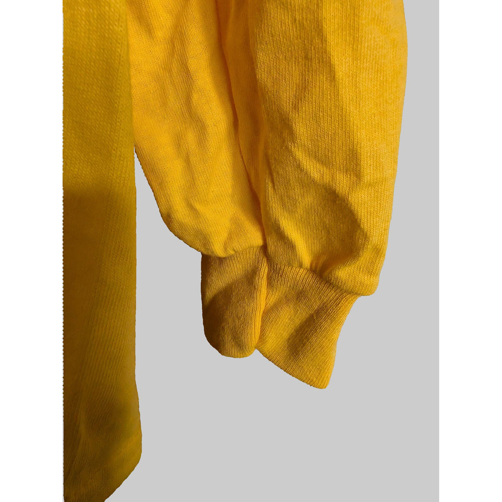 Yellow sweatshirt on a wooden surface