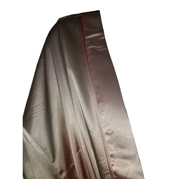 Close-up of a beige fabric with a subtle pattern on a dark background