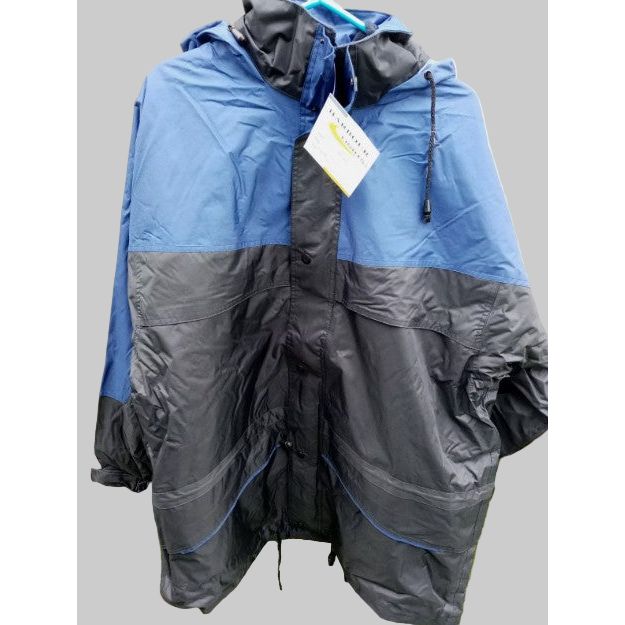 Blue and gray raincoat with a tag on a grassy background