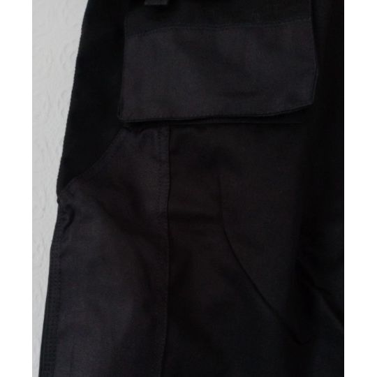 Close-up of black trouser pocket on a light grey background