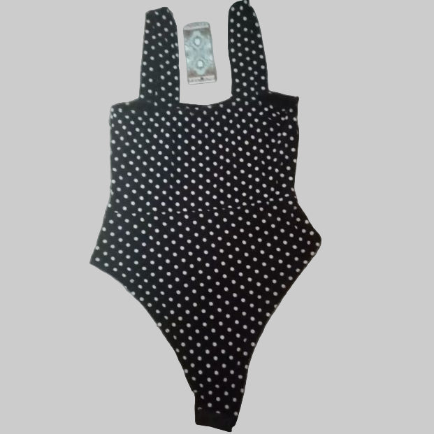 Black polka dot swimsuit on a gray surface
