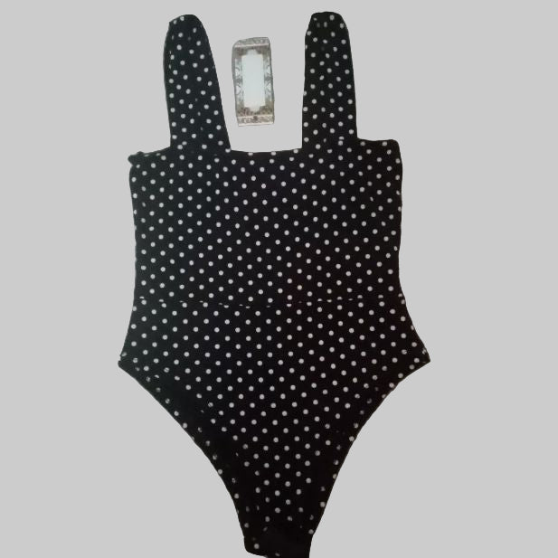 Black polka dot swimsuit on a gray background