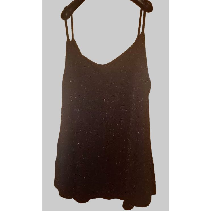 Black dress with thin straps hanging on a wooden door