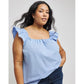 Woman wearing a light blue top with ruffled shoulders against a plain background