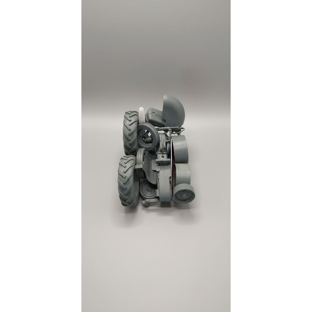 Gray mechanical model with large wheels on a clear plastic base