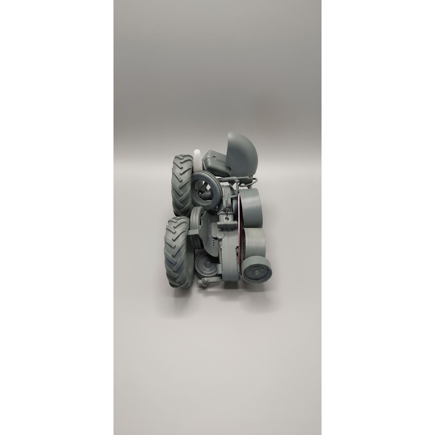 Gray mechanical model with large wheels on a clear plastic base