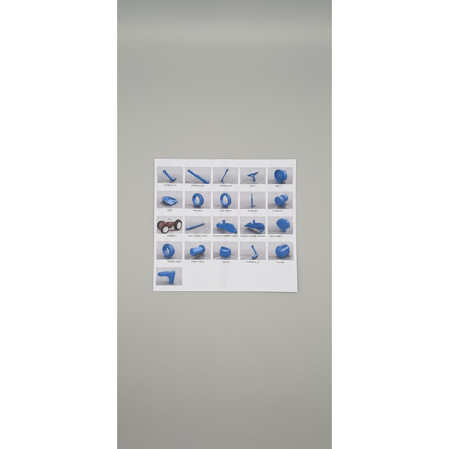 Sheet with blue plastic parts and labels on a textured surface