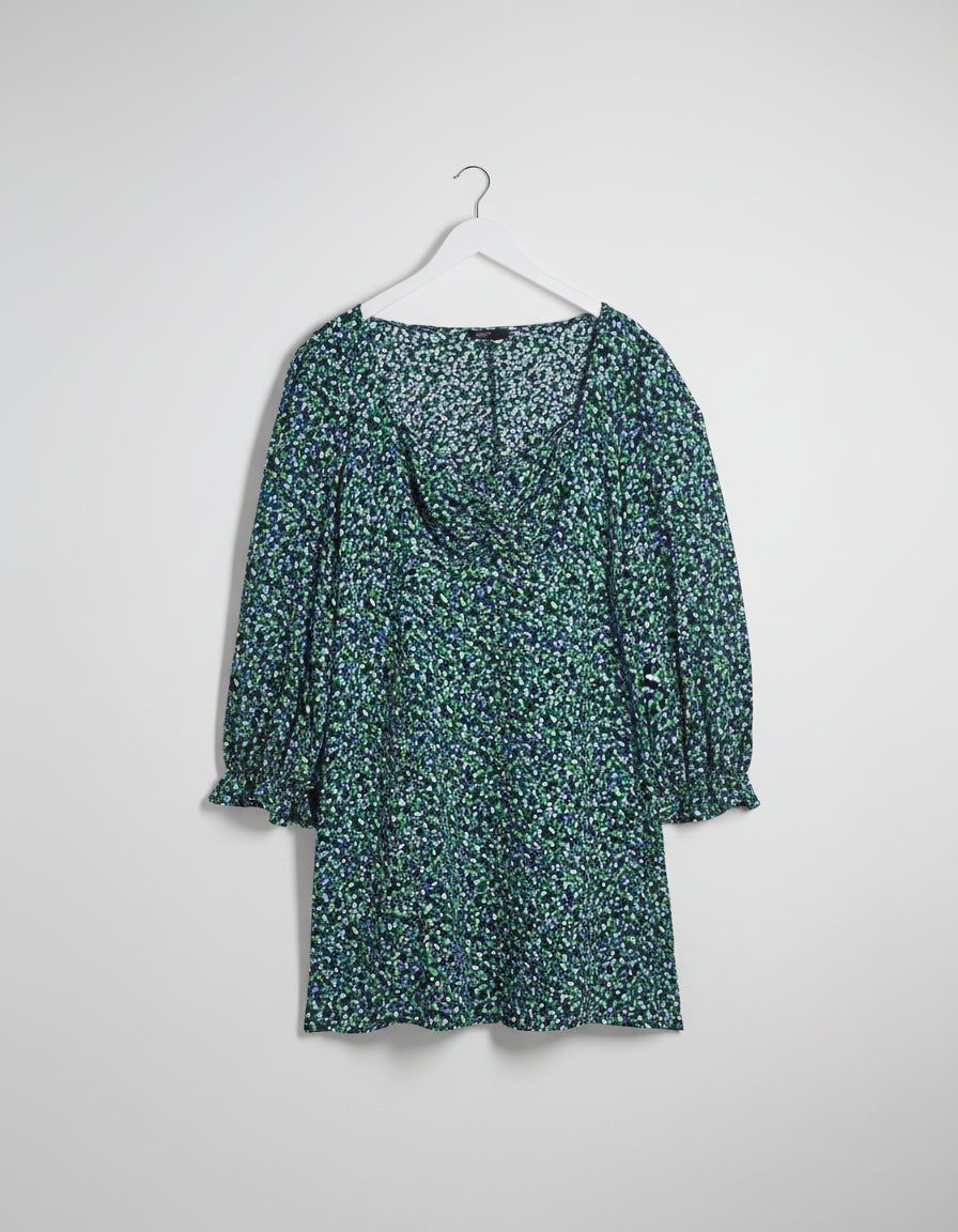 Floral dress on a hanger against a white background