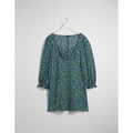 Floral dress on a hanger against a white background